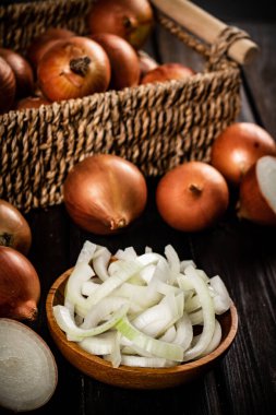 Tabakta soğan parçaları ve bir kutuda bütün soğan. Ahşap bir arka planda. Yüksek kalite fotoğraf