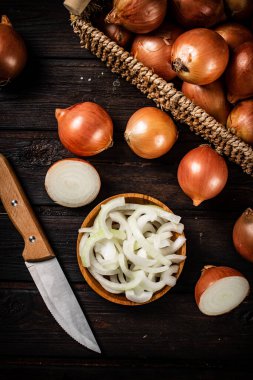 Tabakta soğan parçaları ve bir kutuda bütün soğan. Ahşap bir arka planda. Yüksek kalite fotoğraf