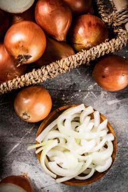 Bir tabakta doğranmış soğan ve bir kutuda bütün. Gri bir arka planda. Yüksek kalite fotoğraf