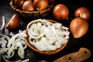 Masadaki ahşap tabakta soğan parçaları. Karanlık bir arka plana karşı. Yüksek kalite fotoğraf