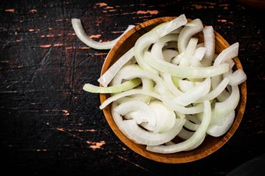 Masadaki ahşap tabakta soğan parçaları. Karanlık bir arka plana karşı. Yüksek kalite fotoğraf