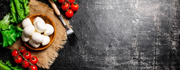トマトとレタスとナプキンのプレートにモッツァレラチーズ 黒を背景に 高品質の写真 — ストック写真