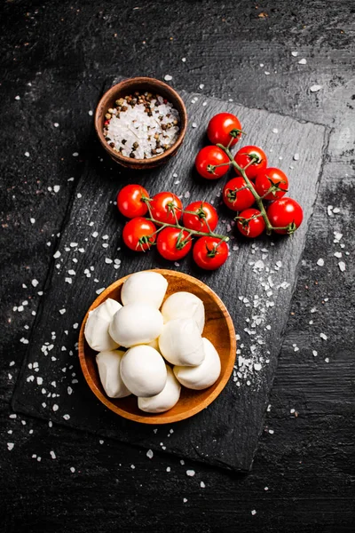 トマトとスパイスと石板上のプレートにモッツァレラチーズ 黒を背景に 高品質の写真 — ストック写真