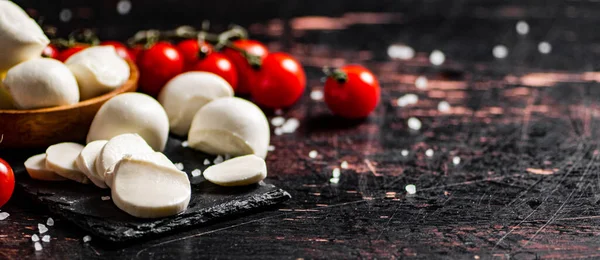 Mozzarella Cortado Uma Placa Pedra Com Tomates Contra Fundo Escuro — Fotografia de Stock
