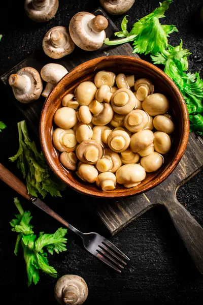 stock image Delicious pickled mushrooms on a cutting board. On a black background. High quality photo