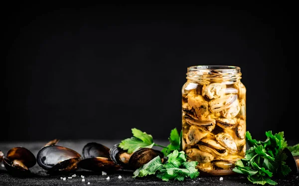 stock image Delicious pickled mussels with parsley on the table. On a black background. High quality photo