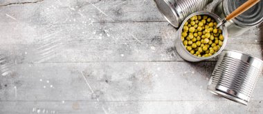 Konserve yeşil bezelyeli ve kaşıklı teneke kutuyu aç. Gri bir arka planda. Yüksek kalite fotoğraf