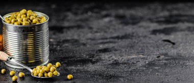 Yeşil bezelyeli açık bir teneke kutu. Siyah bir arka planda. Yüksek kalite fotoğraf