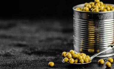 Yeşil bezelyeli açık bir teneke kutu. Siyah bir arka planda. Yüksek kalite fotoğraf