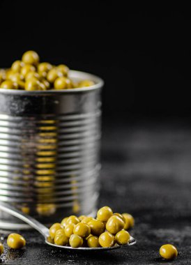 Yeşil bezelyeli açık bir teneke kutu. Siyah bir arka planda. Yüksek kalite fotoğraf