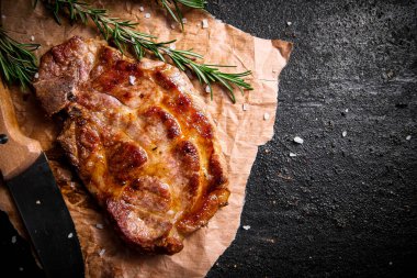 Biberiyeli ızgara domuz bifteği. Siyah bir arka planda. Yüksek kalite fotoğraf