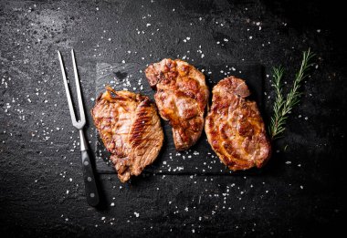 Biberiyeli ızgara domuz bifteği. Siyah bir arka planda. Yüksek kalite fotoğraf