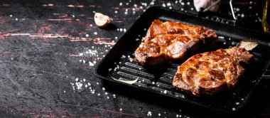 Kızartma tavasında ızgara domuz eti. Karanlık bir arka plana karşı. Yüksek kalite fotoğraf