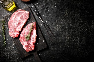 Biberiyeli et dilimleme tahtasında çiğ domuz eti. Siyah bir arka planda. Yüksek kalite fotoğraf