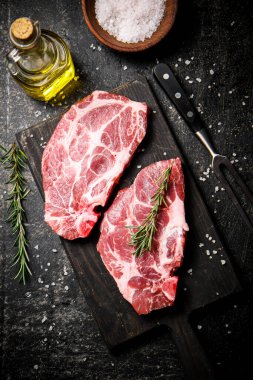 Biberiyeli et dilimleme tahtasında çiğ domuz eti. Siyah bir arka planda. Yüksek kalite fotoğraf