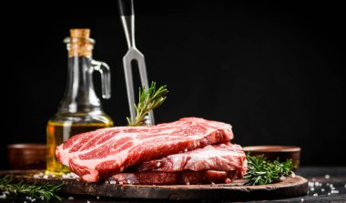 Kesme tahtasında çatallı çiğ domuz eti. Siyah bir arka planda. Yüksek kalite fotoğraf