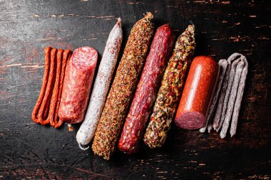 Çeşitli aromatik salam sosisleri. Karanlık bir arka plana karşı. Yüksek kalite fotoğraf