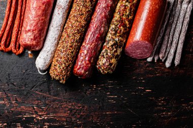 Çeşitli aromatik salam sosisleri. Karanlık bir arka plana karşı. Yüksek kalite fotoğraf