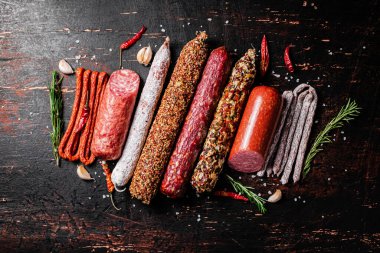 Çeşitli aromatik salam sosisleri. Karanlık bir arka plana karşı. Yüksek kalite fotoğraf
