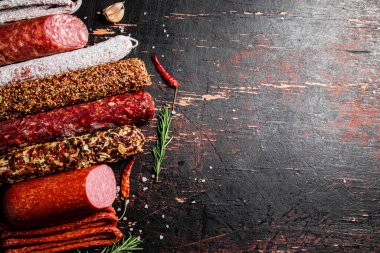 Çeşitli aromatik salam sosisleri. Karanlık bir arka plana karşı. Yüksek kalite fotoğraf