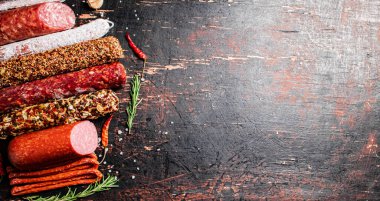 Çeşitli aromatik salam sosisleri. Karanlık bir arka plana karşı. Yüksek kalite fotoğraf