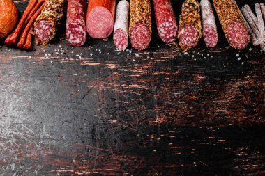 Arka arkaya çeşitli salam sosisleri. Karanlık bir arka plana karşı. Yüksek kalite fotoğraf