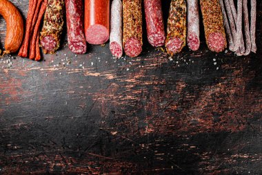 Arka arkaya çeşitli salam sosisleri. Karanlık bir arka plana karşı. Yüksek kalite fotoğraf