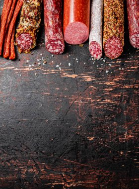 Arka arkaya çeşitli salam sosisleri. Karanlık bir arka plana karşı. Yüksek kalite fotoğraf