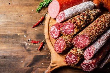 Tahta kesme tahtasındaki farklı salam türleri. Ahşap bir arka planda. Yüksek kalite fotoğraf