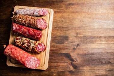 Tahta kesme tahtasındaki farklı salam türleri. Ahşap bir arka planda. Yüksek kalite fotoğraf