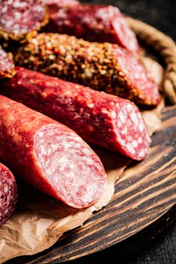 Kesme tahtasındaki farklı salam türleri. Karanlık bir arka plana karşı. Yüksek kalite fotoğraf