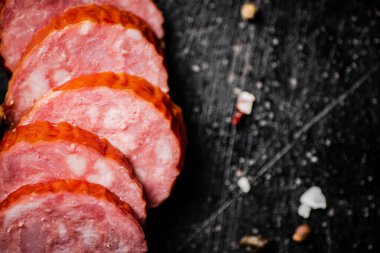 Yuvarlak salam sosisi dilimlerine ayır. Siyah bir arka planda. Yüksek kalite fotoğraf