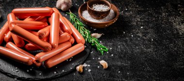 Baharat ve biberiyeyle kaynatılmış sosisler. Siyah bir arka planda. Yüksek kalite fotoğraf