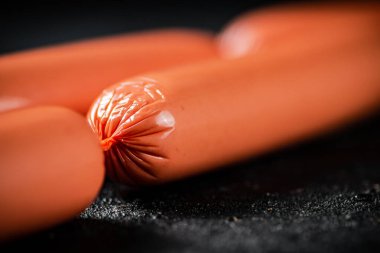 Lezzetli sosisler masada kaynatıldı. Siyah bir arka planda. Yüksek kalite fotoğraf