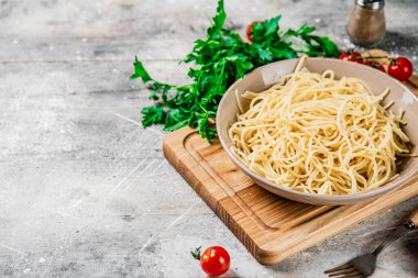 Maydanozlu makarnada haşlanmış spagetti. Gri bir arka planda. Yüksek kalite fotoğraf