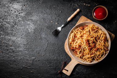 Masada spagetti bolonez hazır. Siyah bir arka planda. Yüksek kalite fotoğraf