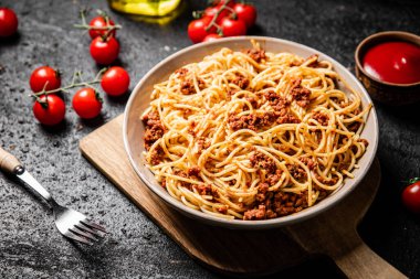 Kiraz domatesli bir kasede leziz spagetti bolonezi. Siyah bir arka planda. Yüksek kalite fotoğraf