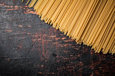 Masada kurumuş bir spagetti yığını. Karanlık bir arka plana karşı. Yüksek kalite fotoğraf