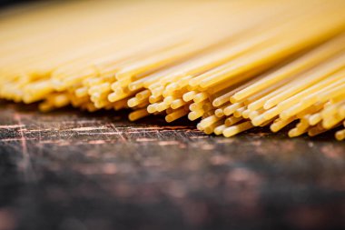 Masada kurumuş bir spagetti yığını. Karanlık bir arka plana karşı. Yüksek kalite fotoğraf