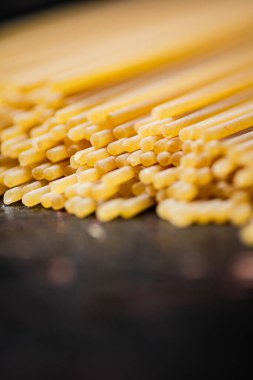 Masada kurumuş bir spagetti yığını. Karanlık bir arka plana karşı. Yüksek kalite fotoğraf