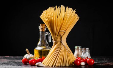 Masanın üzerinde bir halatla bağlanmış bir spagetti paketi. Siyah bir arka planda. Yüksek kalite fotoğraf