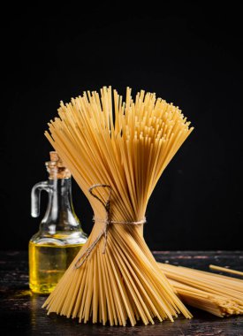 Masanın üzerinde bir halatla bağlanmış bir spagetti paketi. Siyah bir arka planda. Yüksek kalite fotoğraf