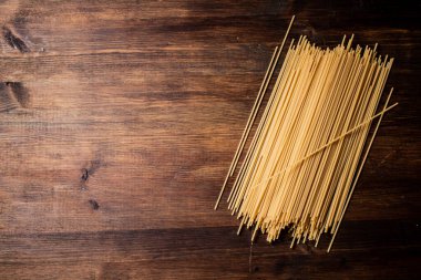 Masada bir demet spagetti kurudu. Ahşap bir arka planda. Yüksek kalite fotoğraf