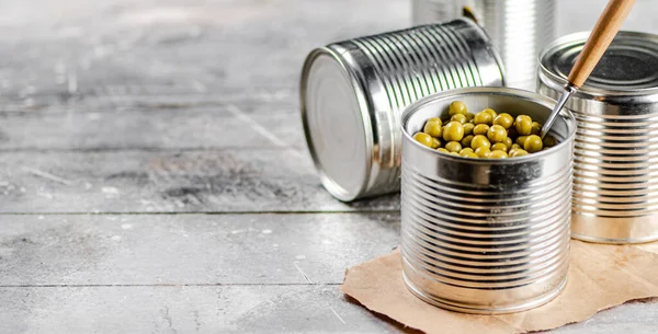 缶詰の緑のエンドウ豆をスプーンで開くことができます 灰色の背景で 高品質の写真 — ストック写真