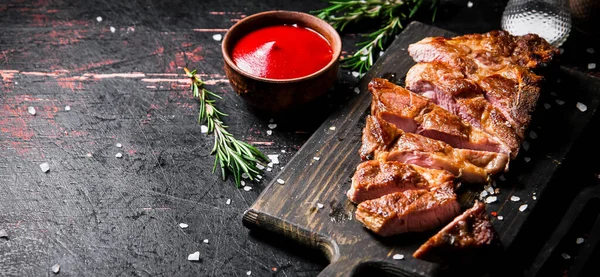 Scheiben Gegrilltes Schweinefleisch Auf Einem Holzschneidebrett Vor Einem Dunklen Hintergrund — Stockfoto