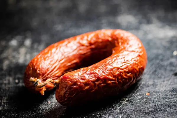 stock image Delicious salami sausage on the table. On a black background. High quality photo