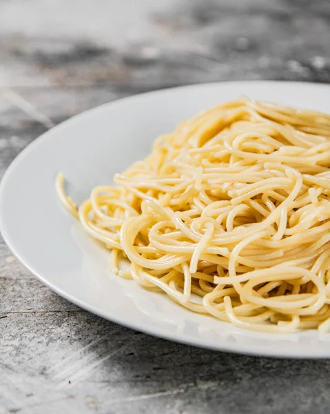 Des Spaghettis Bouillis Dans Une Assiette Sur Fond Gris Photo — Photo