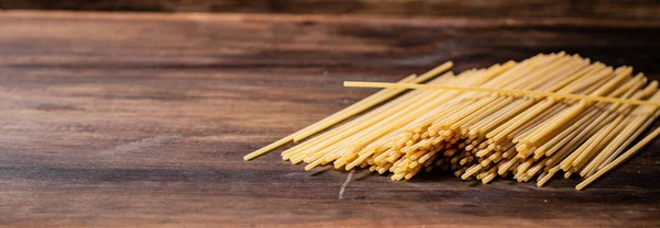 Mazzo Spaghetti Asciutti Sul Tavolo Uno Sfondo Legno Foto Alta — Foto Stock