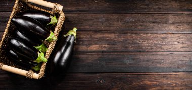 Box on a table with ripe eggplant. On a wooden background. High quality photo