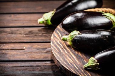 Ripe eggplant on a wooden tray. On a wooden background. High quality photo